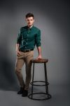 Serious handsome young man sitting isolated
